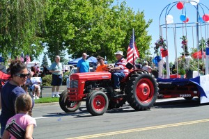 A tractor pulls a float at the 2014 "Red, White & Blue" Parade.