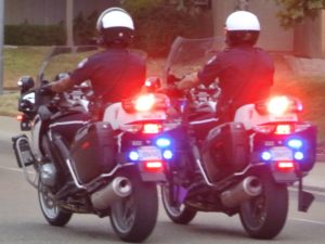 Two Police Officers on Motorcycles with Lights On