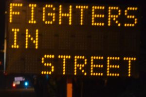 Fire fighters in street, sign. Charity event in Citrus Heights. Photo by Luke Otterstad