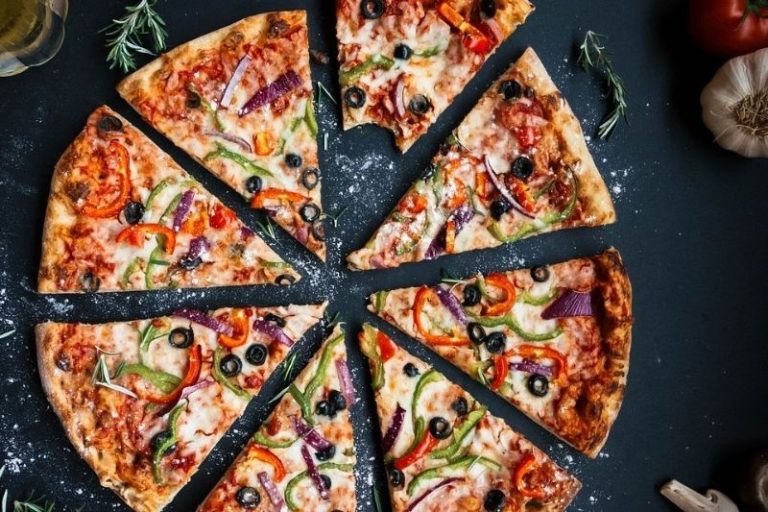 Whole pizza with bite in slice