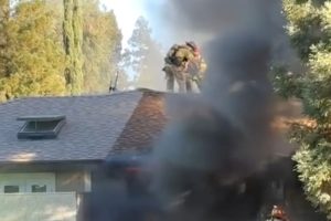 Crews on the roof of a burning house