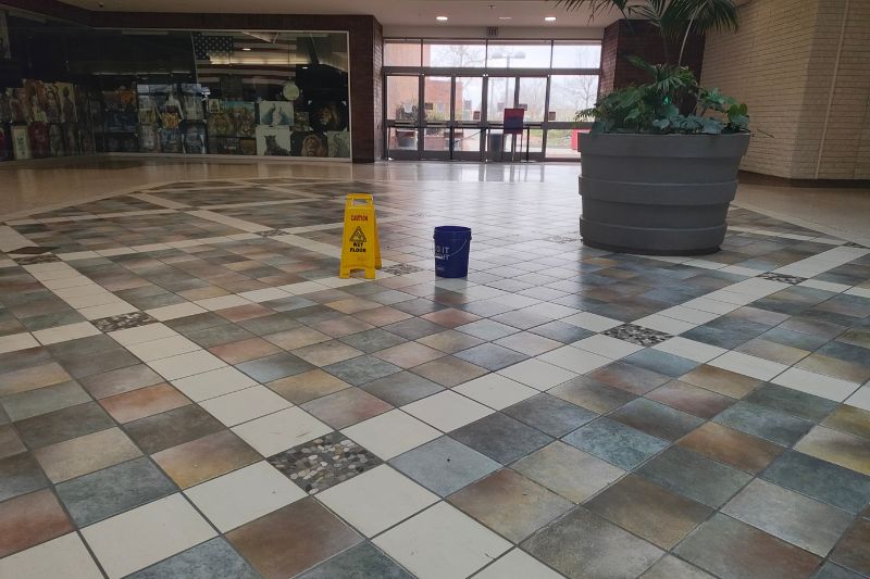 At least three buckets were observed in December 2024 by The Sentinel staff in the Sunrise Mall main corridor, positioned to catch water from the leaking roof. // SB Williams