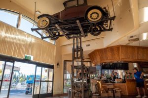Western States Mechanical Owner Jesse Larranaga lifts the 1930 Ford Model A with a forklift as Randy Pastor looks on with family and friends of this gas station.