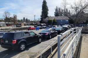 Dozens of vehicles wait in line at Sunrise Christian Food Ministry for food. // SB Williams
