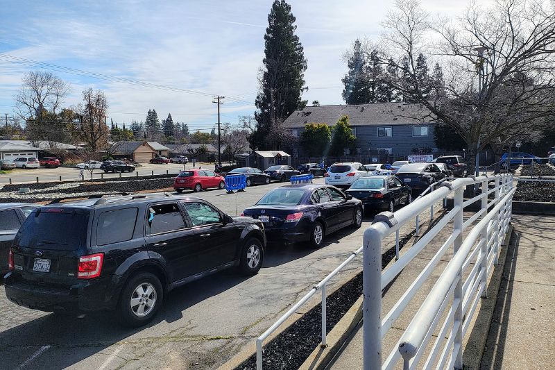 Dozens of vehicles wait in line at Sunrise Christian Food Ministry for food. // SB Williams