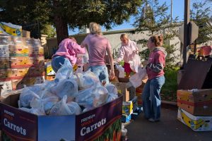Dutch Bros coffee shop manager and assistant manager from the San Juan Avenue and Madison Avenue Dutch Bros spent Thursday, Feb. 5 volunteering at Sunrise Christian Food Ministry ahead of the company's annual "Dutch Luv" fundraising event. // SB Williams