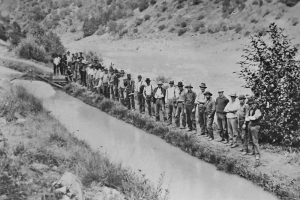Workers for the North Fork Ditch Company line up by the North Fork Ditch that ran alongside the North Fork of the American River. The NFD received water from a diversion dam near the town of Auburn and brought it down to Baldwin Reservoir, located by the Northeast corner of Orangevale. The water served gold miners in the 1800s and farmers and ranchers in the first have of the 1900s. The Orangevale, Fair Oaks and Citrus Heights Irrigation Districts all received water from this ditch. Its’ use was discontinued with the construction of Folsom Dam. // Citrus Heights Historical Society