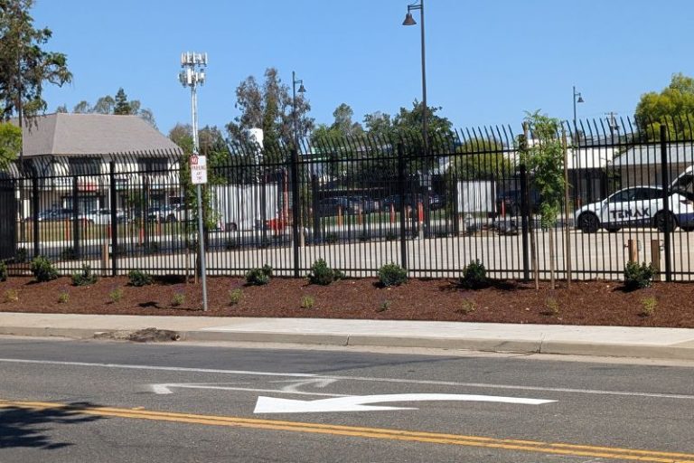 A long-vacant lot overgrown with weeds is being transformed into a food truck plaza with new landscaping and fencing.