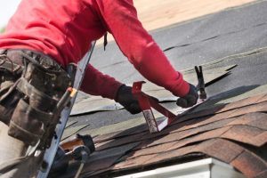Crews repair the roof of a residential home. stock photo