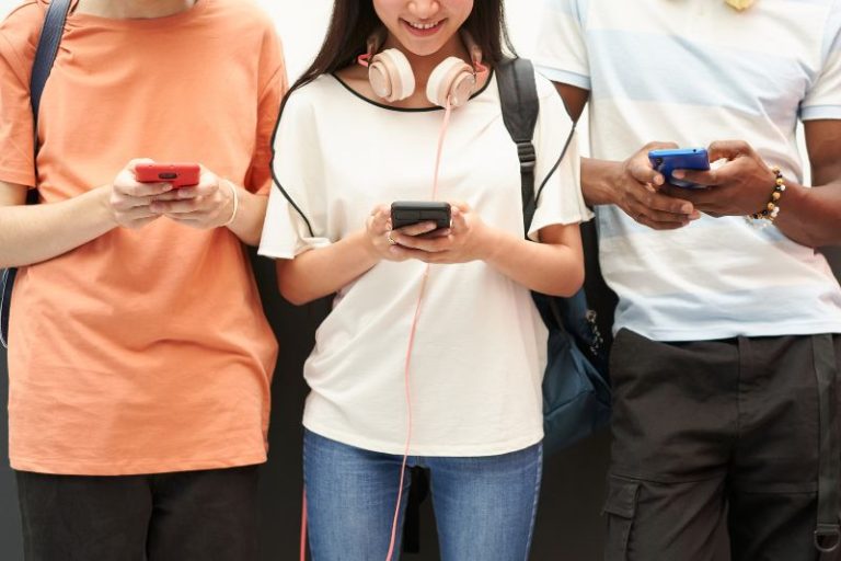 Students using cell phones. Stock photo.